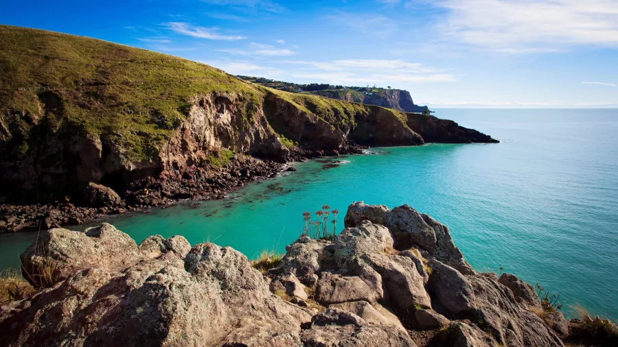 Rocky coastal cliffs and calm turquoise waters near Boulder Bay on Banks Peninsula