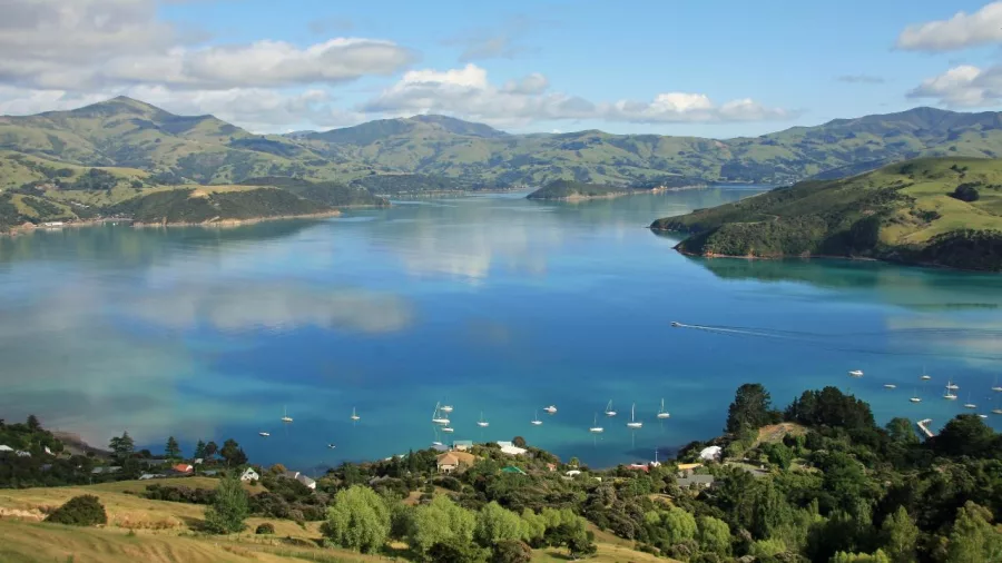 Picturesque view of Akaroa village and harbour with boats in the bay