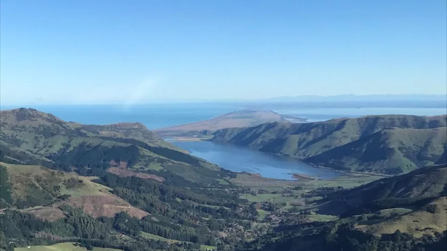 Aerial view of Lake Forsyth nestled in Banks Peninsula’s rugged volcanic landscape