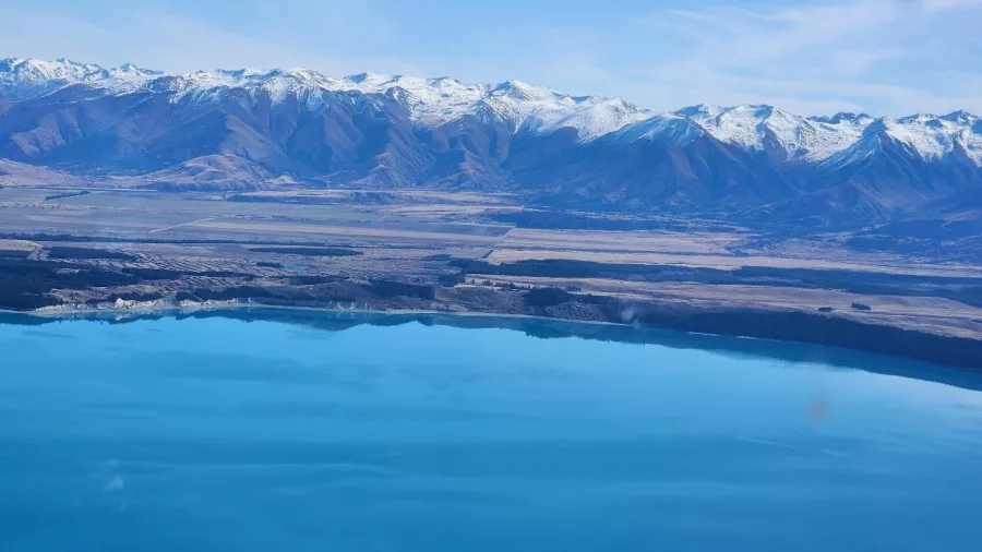 Aerial view of Lake Ōhau with snow-capped Southern Alps in the distance