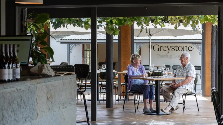 Elderly couple enjoying a wine tasting inside the Greystone Winery tasting lounge
