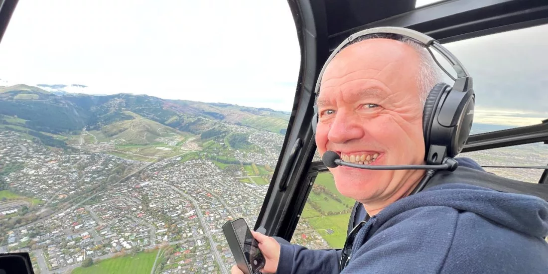 Happy helicopter passenger overlooking Christchurch cityscape