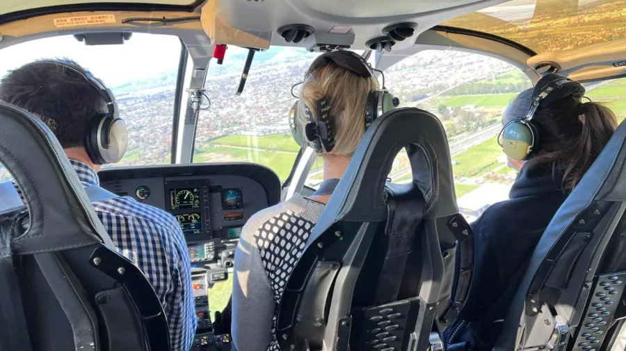 View from helicopter cockpit flying over Christchurch suburbs