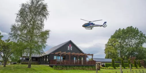 Helicopter arriving above Melton Estate Winery surrounded by vines in West Melton, Christchurch