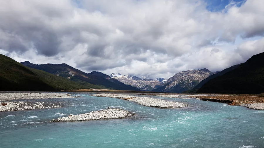 Turquoise waters of the Waimakariri River flowing through rocky riverbeds surrounded by mountains