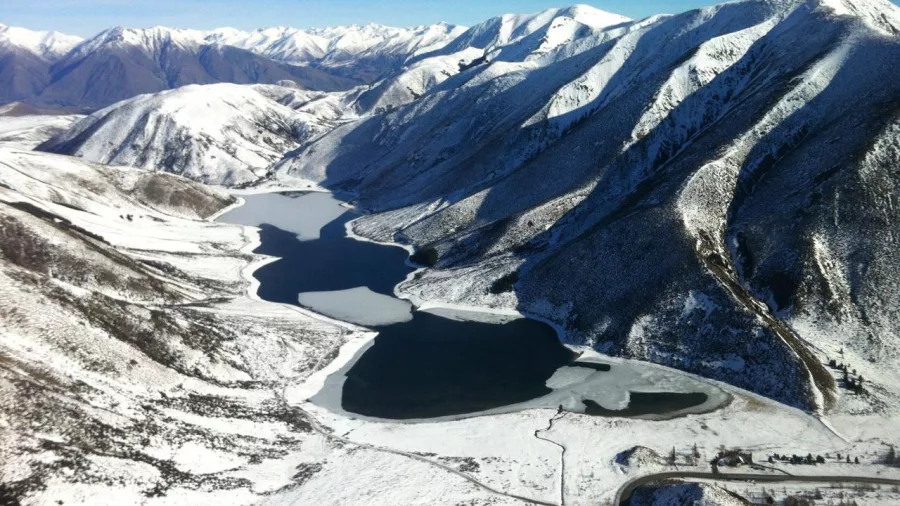 Frozen lakes nestled among snowy mountain ranges on a winter helicopter flight in the Southern Alps
