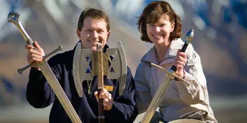 Guests holding replica swords and axes from the Lord of the Rings at Edoras location.