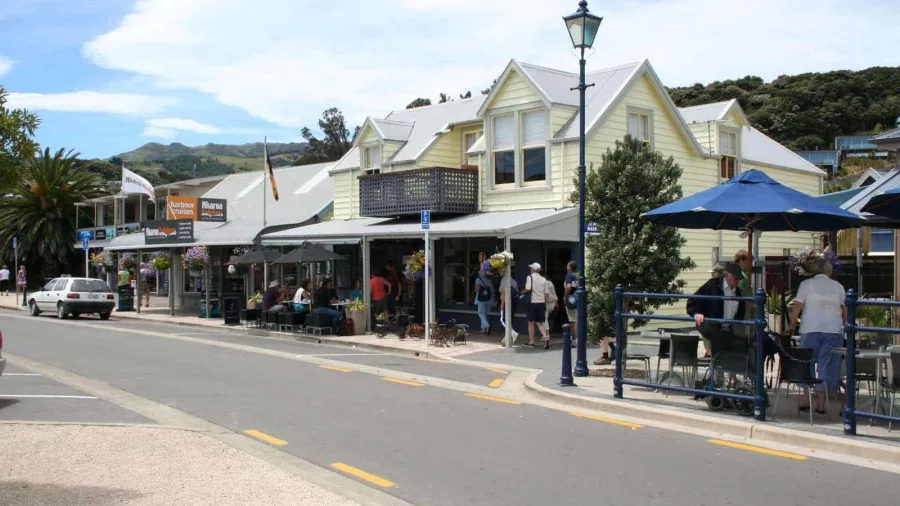 Akaroa town centre with colonial buildings, cafes, and visitors along the street