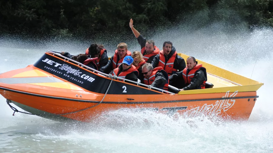 Smiling passengers on a jet boat adventure along the Waimakariri River in Canterbury