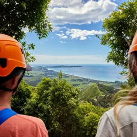 Two ziplining guests admire the ocean view from a lookout point in Kaikōura.