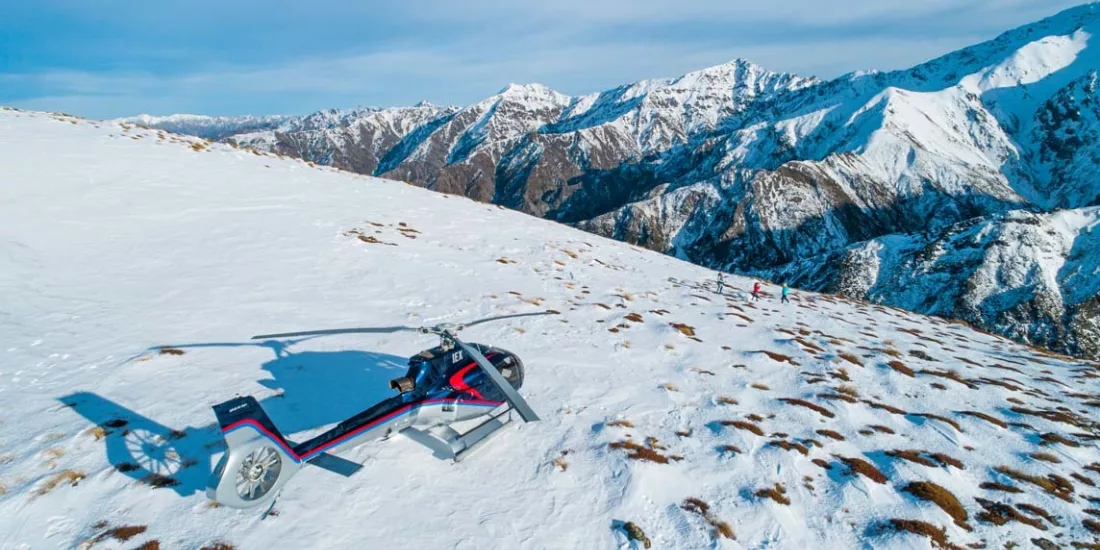 Helicopter landed on a snow-covered mountain with panoramic views of the Kaikōura Ranges