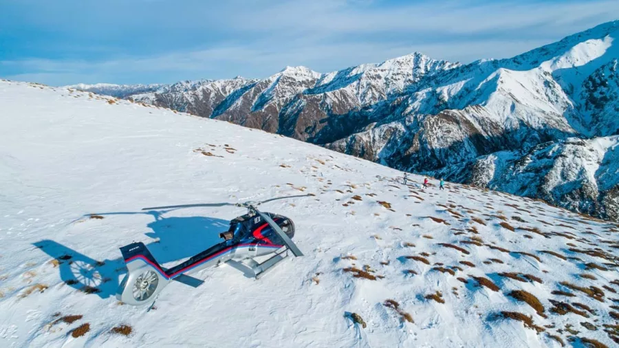 Helicopter landed on a snow-covered mountain with panoramic views of the Kaikōura Ranges