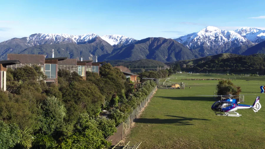Helicopter landed next to Hapuku Lodge with snow-capped Kaikōura Ranges in the background