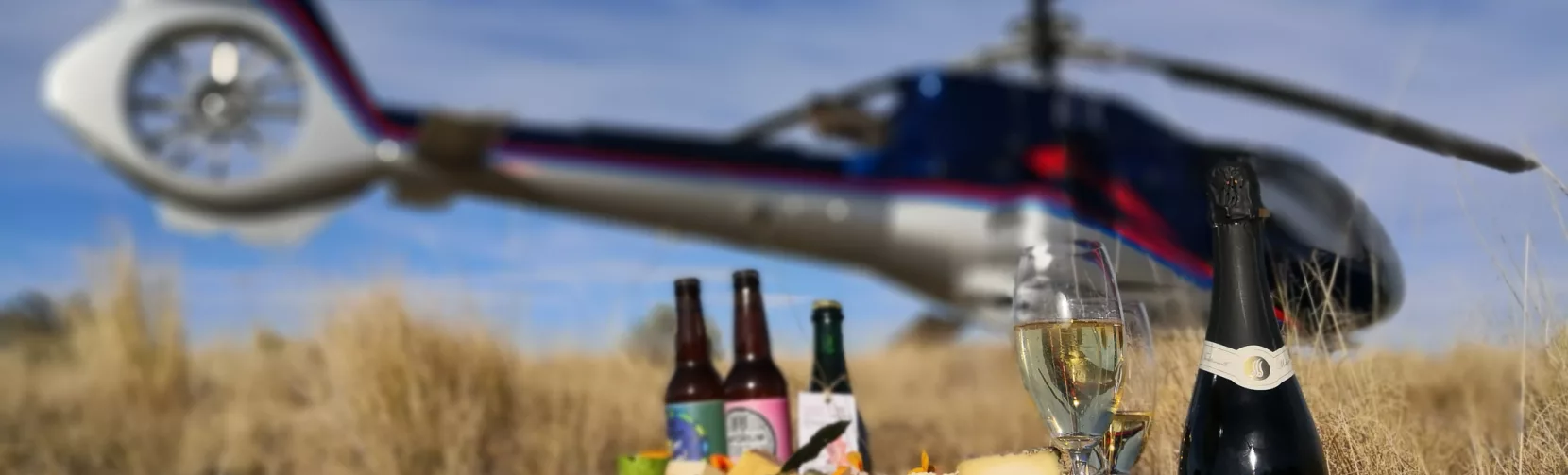 Cheese platter with local wine and craft beer in front of a Kaikōura Helicopters landing site