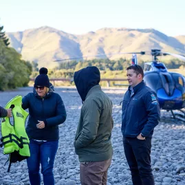 Helicopter with guests arriving at the Hurunui River landing zone on a sunny day