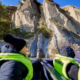 Jet boat passengers passing close to steep canyon walls along the Hurunui River