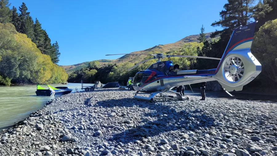 Kaikōura Helicopters aircraft beside Energy Jet boat on a remote Canterbury riverbed