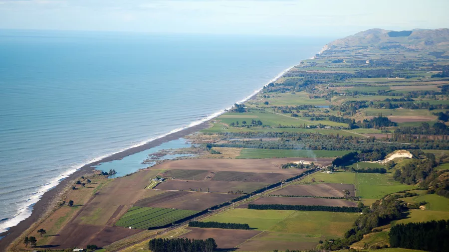 Aerial view of Kaikōura coastline stretching north with rural farmland