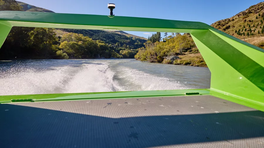 View from the back of the jet boat showing wake and river scenery in Canterbury