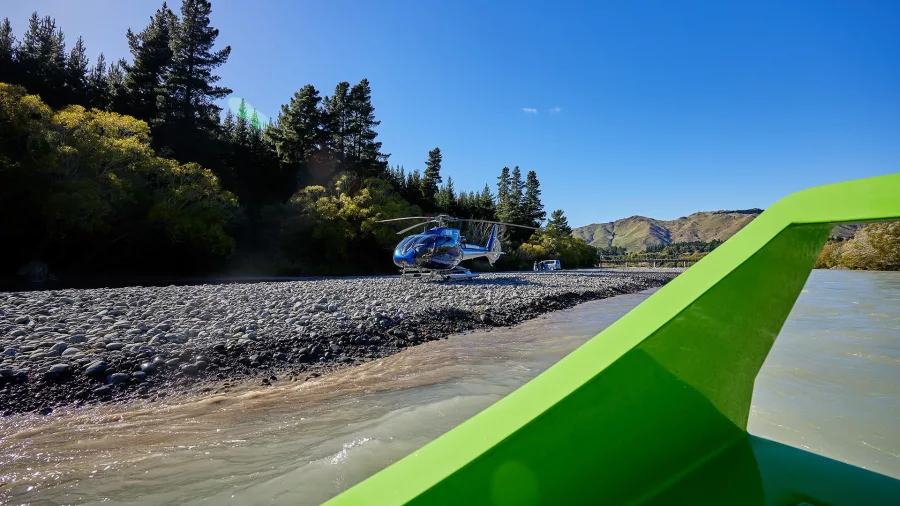 View from jet boat approaching helicopter on the Hurunui River gravel bar