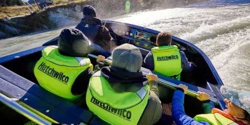 Jet boat performing a thrilling 360-degree spin on the river during Heli-Jet Adventure