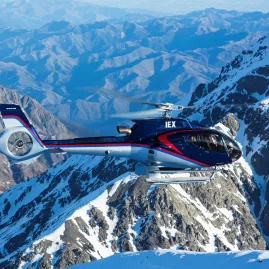 Kaikōura Helicopters navigating through snowy Seaward Ranges with deep valleys below