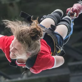 Woman smiling mid-fall during a solo bungy jump in Hanmer Springs