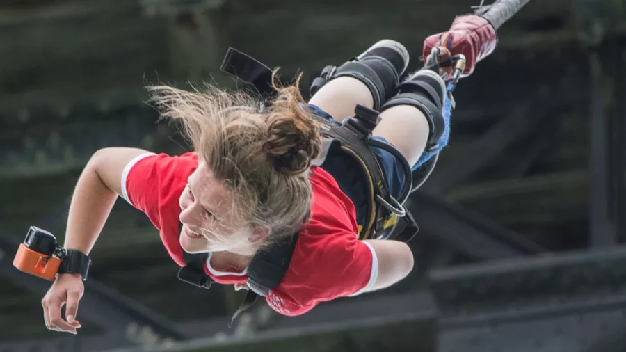 Woman smiling mid-fall during a solo bungy jump in Hanmer Springs