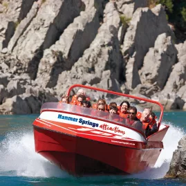 Hanmer Springs jet boat cruising close to river rocks on a thrilling ride along the Waiau Gorge