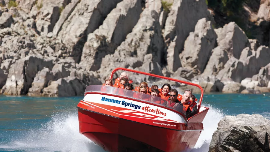 Hanmer Springs jet boat cruising close to river rocks on a thrilling ride along the Waiau Gorge