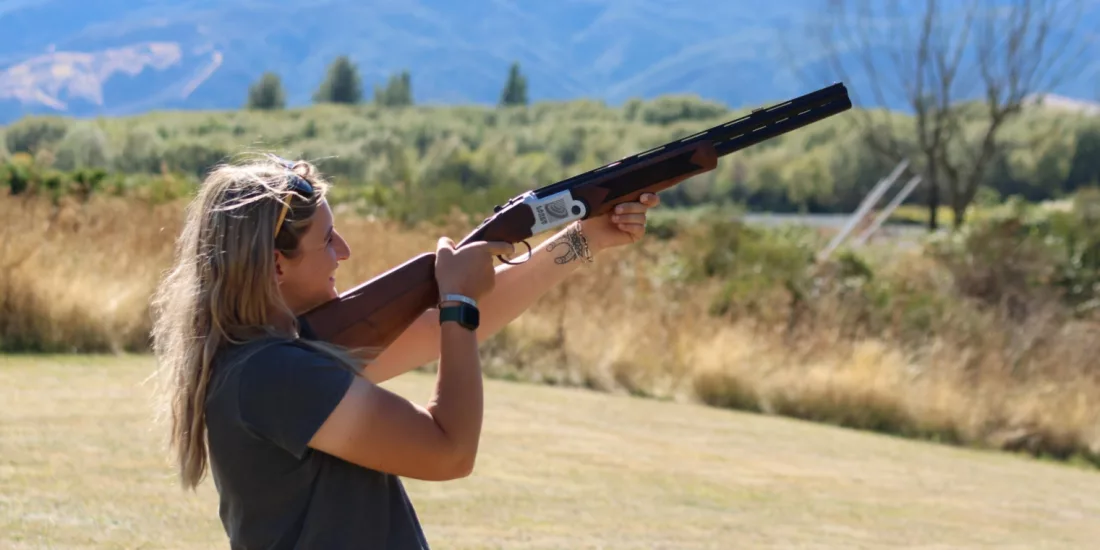 Woman aiming a laser clay shooting gun at moving targets in Hanmer Springs