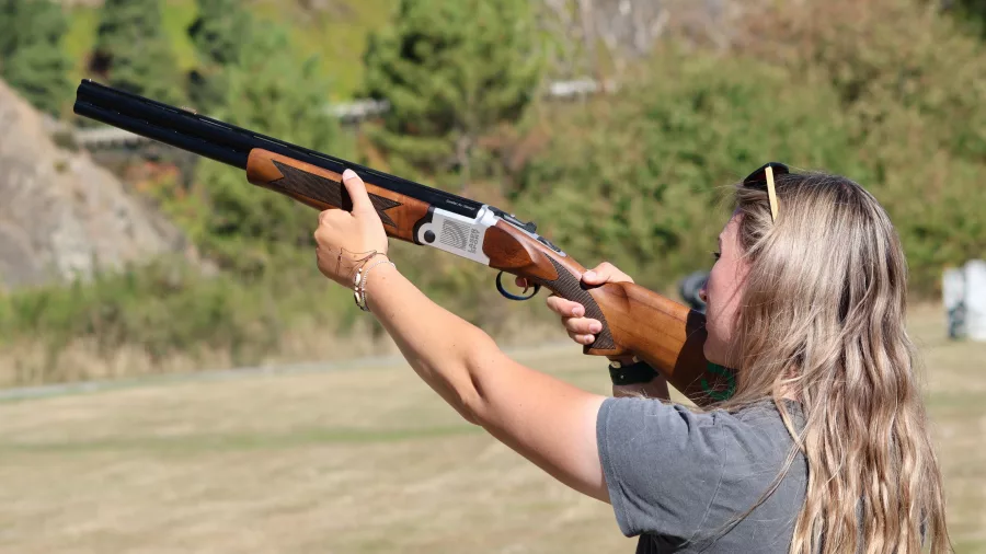 Close-up of a woman aiming a laser clay shooting gun during an outdoor session in Hanmer Springs