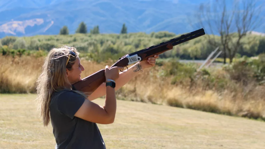 Woman aiming a laser clay shooting gun at moving targets in Hanmer Springs