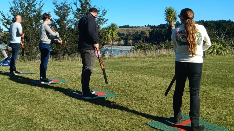 Participants lining up for laser clay target shooting with scenic views near Hanmer Springs