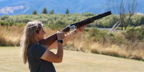 Woman aiming a laser clay shooting gun at moving targets in Hanmer Springs