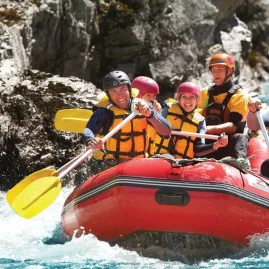 Rafters powering through gentle rapids with big smiles on a Hanmer Springs Attractions rafting tour