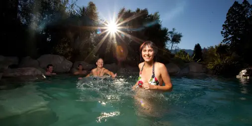 Woman enjoying a thermal rock pool at sunset in Hanmer Springs