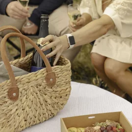 Couple enjoying a gourmet picnic with wine and cheese during a Mt Fyffe heli flight tour in New Zealand.
