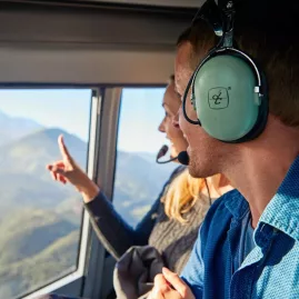Couple enjoying scenic views from helicopter cabin during Mt Fyffe flight