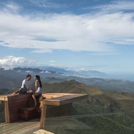 Couple enjoying panoramic views from a glass deck at Matai Peak, Kaikōura