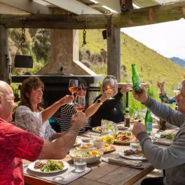 Group enjoying a gourmet lunch and drinks at Matai Peak luxury experience