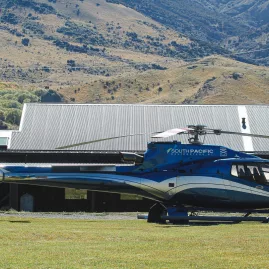 South Pacific Helicopter parked beside farm buildings at Middlehurst Station