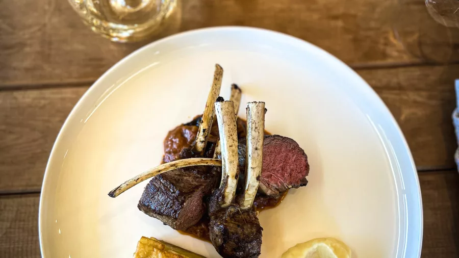 Plated lamb rack with sides and wine glass at Middlehurst Station lunch