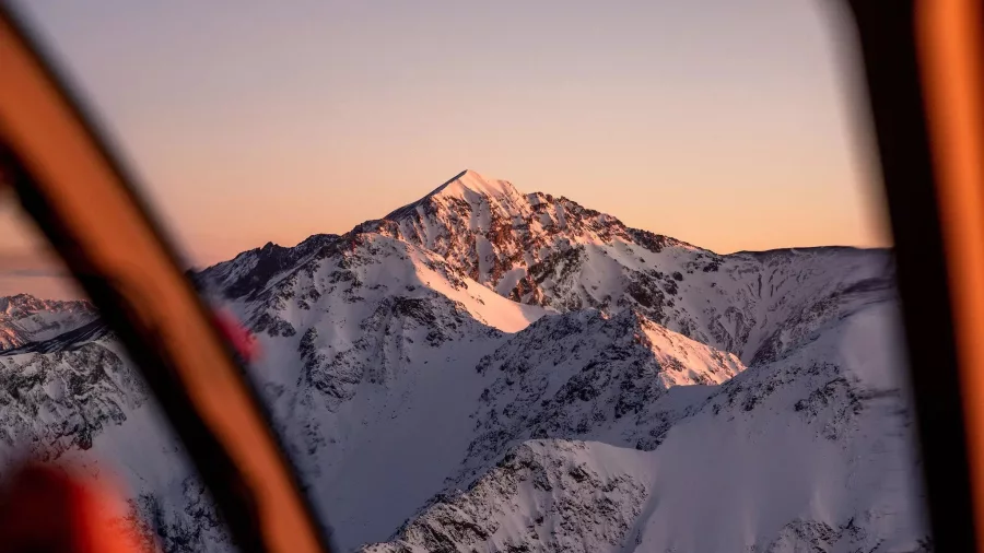 View of Mt Fyffe covered in snow during helicopter flight at sunset