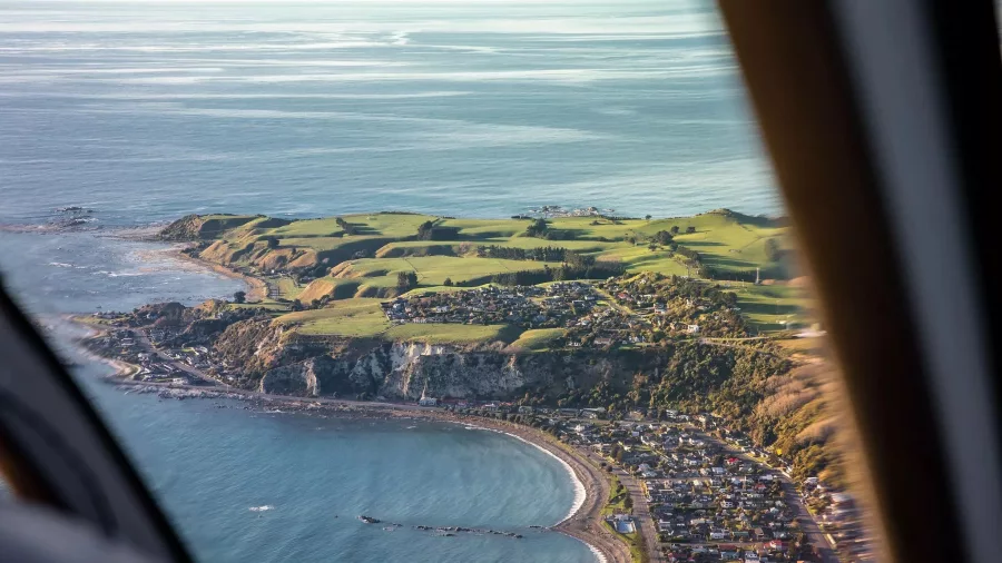 Aerial view of Kaikōura township and coast captured from helicopter window