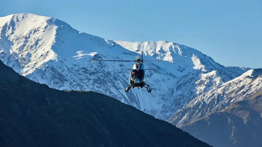 Helicopter flying towards snowy Seaward Kaikōura mountains during Ocean Safari flight