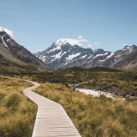 Hooker Valley Track boardwalk leading towards Aoraki/Mount Cook with clear skies and alpine scenery in Aoraki/Mount Cook National Park, New Zealand.