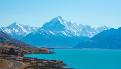 Aoraki/Mount Cook rising above Lake Pukaki with a clear blue sky and snow-covered peaks
