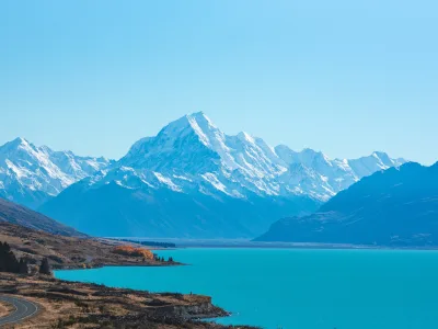 Aoraki/Mount Cook rising above Lake Pukaki with a clear blue sky and snow-covered peaks