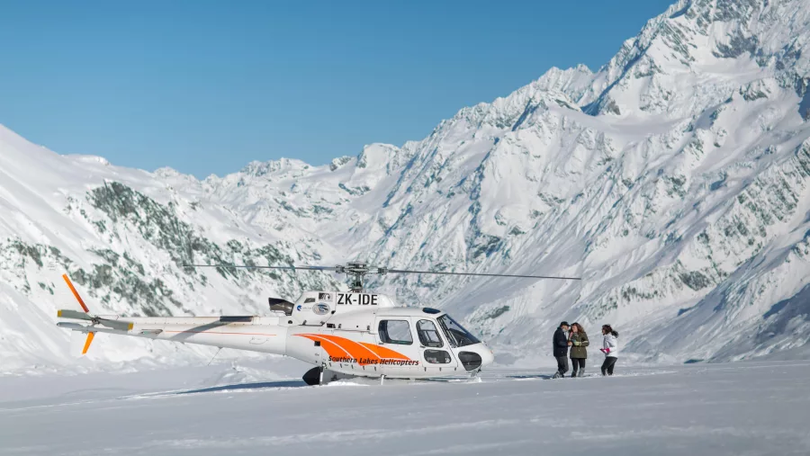 Southern Lakes Helicopters aircraft on a snow landing near Aoraki/Mount Cook, surrounded by the Southern Alps.